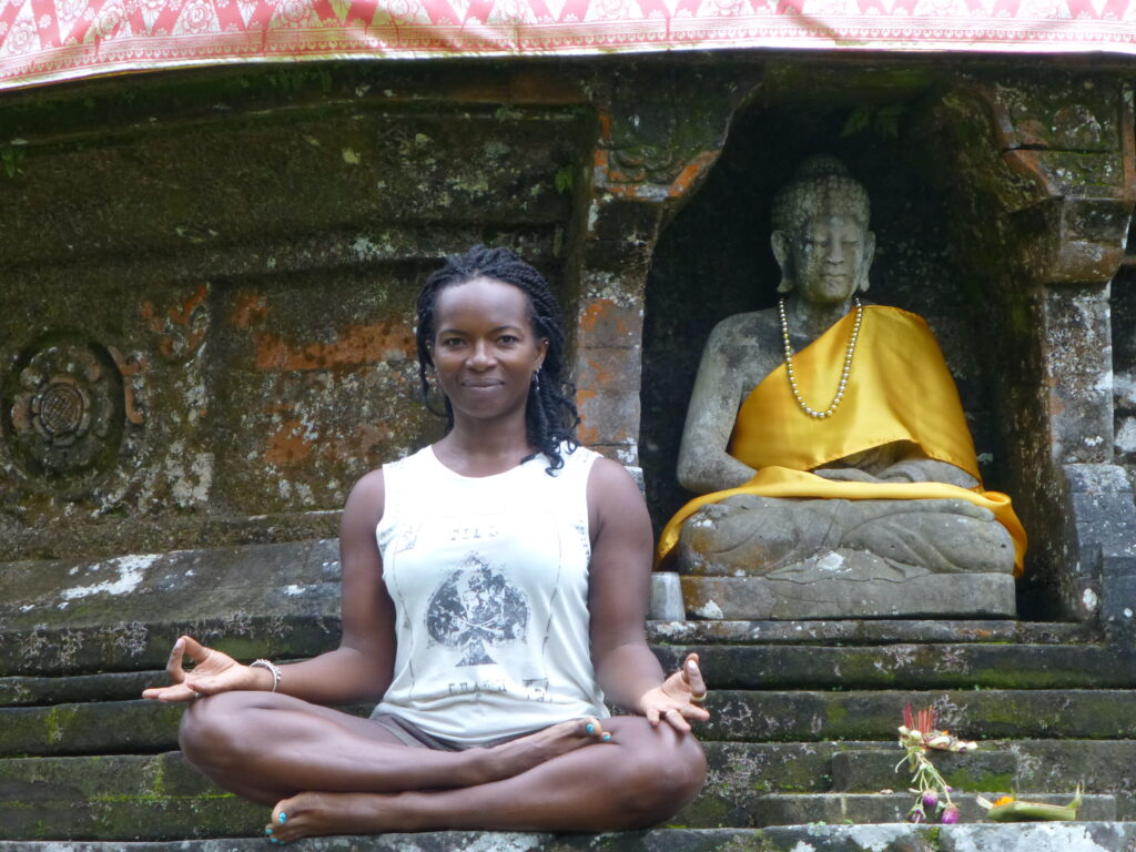 A woman sitting in the middle of stairs next to a statue.