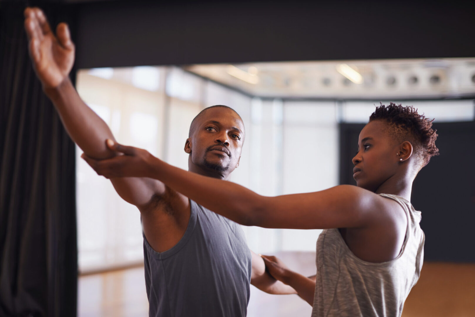 Art, creative or dance with student and teacher in class together for theater performance training. Fitness, learning and school with black man instructor teaching dancer in studio for production.